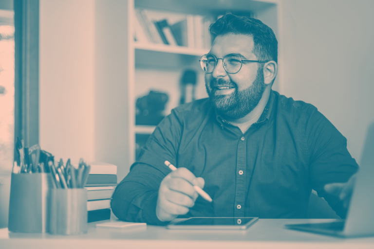 A smiling adult man at desk.