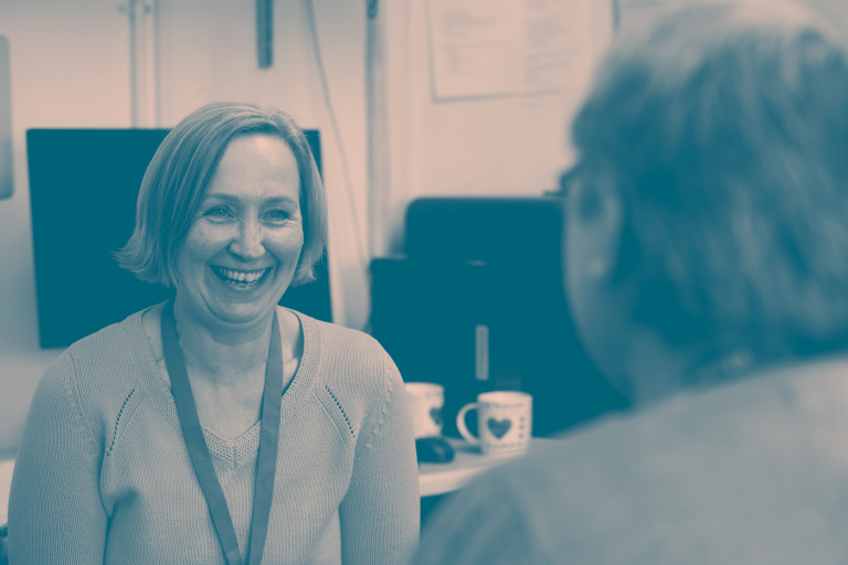 A smiling adult woman in an office.