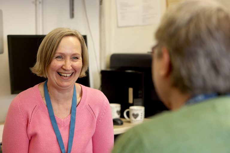A smiling adult woman in an office.